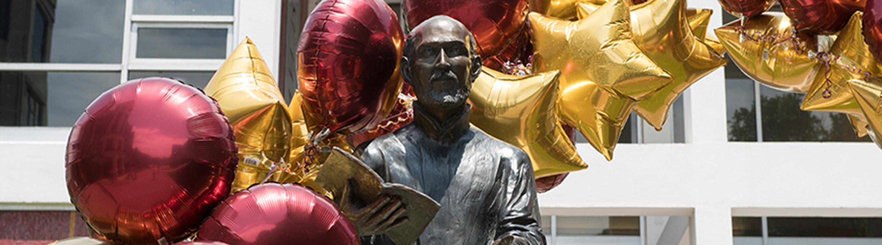 直接拍摄伊格内修斯雕像和栗色和金色的气球